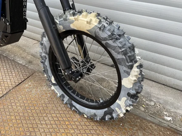 The 16” front wheel is mounted on a Surron e-bike with OFF-ROAD tires.